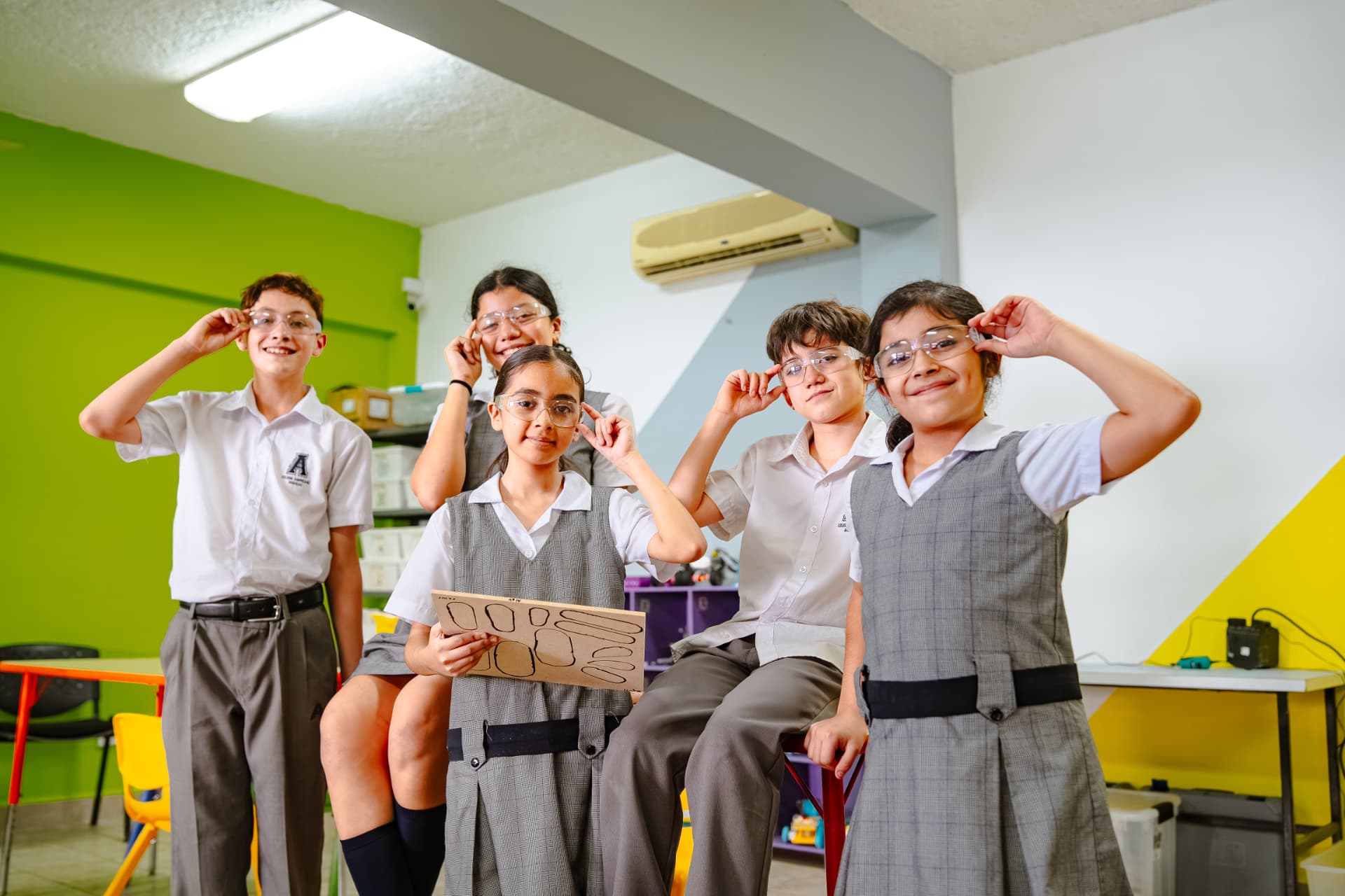 Estudiantes de CREAEDUU mostrando sus gafas de seguridad en el aula